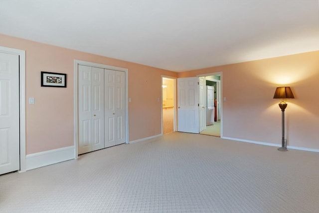 unfurnished bedroom featuring baseboards and light carpet