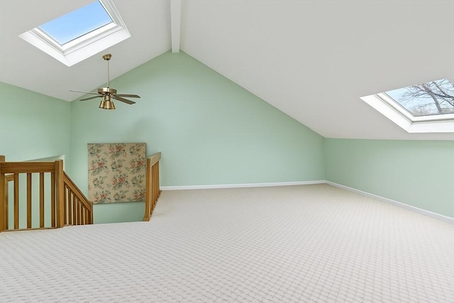 bonus room featuring a skylight, beamed ceiling, carpet flooring, baseboards, and high vaulted ceiling