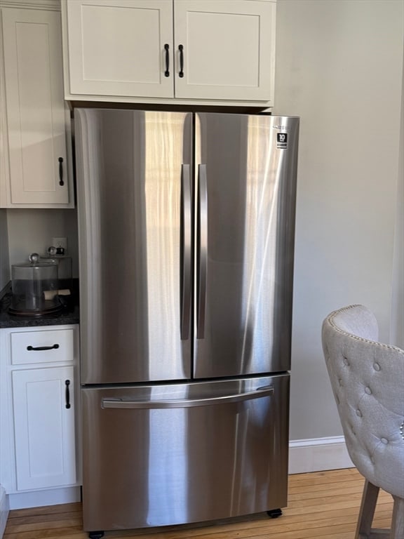 kitchen featuring light hardwood / wood-style flooring, stainless steel refrigerator, and white cabinetry