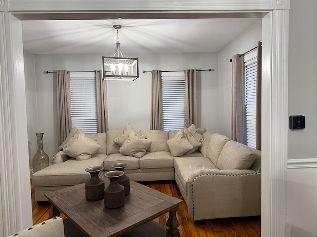 living room with hardwood / wood-style floors and a notable chandelier