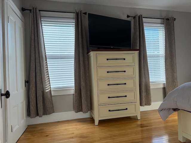 bedroom featuring light hardwood / wood-style flooring and multiple windows