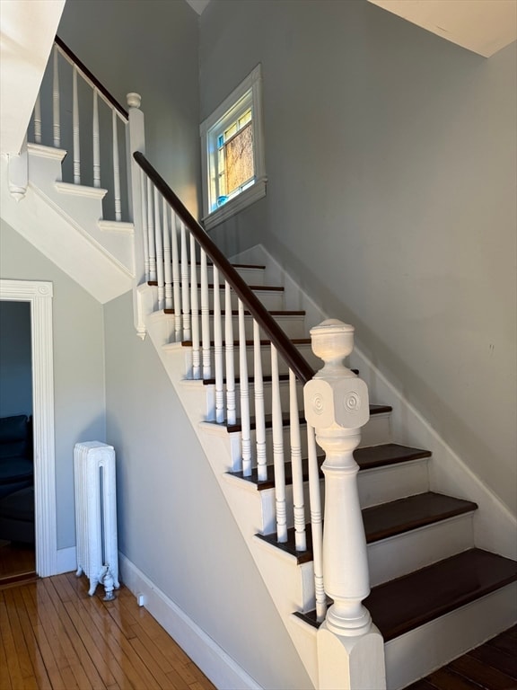 stairway with wood-type flooring and radiator