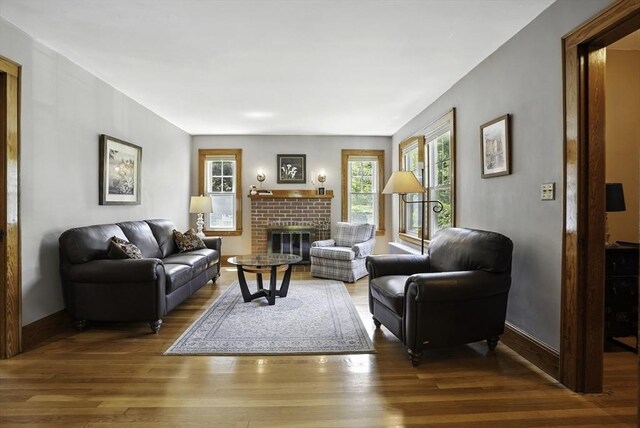247 S St, Wrentham, MA 02093 - living area featuring wood finished floors, a brick fireplace, and baseboards