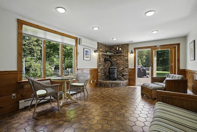 247 S St, Wrentham, MA 02093 - living room featuring a wainscoted wall, healthy amount of natural light, a wood stove, an AC wall unit, and wooden walls