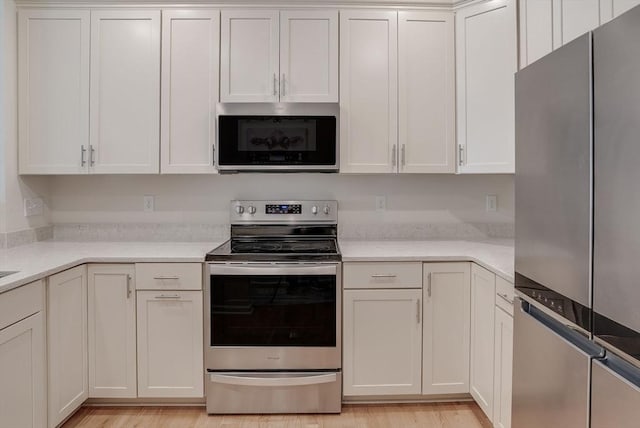 6 Overlook Dr Unit 207, Andover, MA 01810 - kitchen with white cabinetry, light countertops, stainless steel appliances, and light wood finished floors