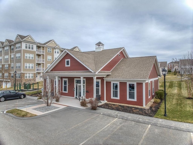6 Overlook Dr Unit 207, Andover, MA 01810 - view of front of house featuring uncovered parking, a front yard, a shingled roof, and a porch