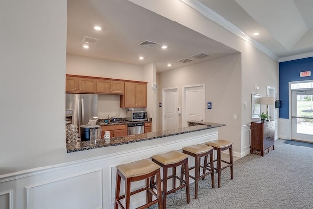 6 Overlook Dr Unit 207, Andover, MA 01810 - kitchen with a breakfast bar area, ornamental molding, stainless steel appliances, light carpet, and wainscoting