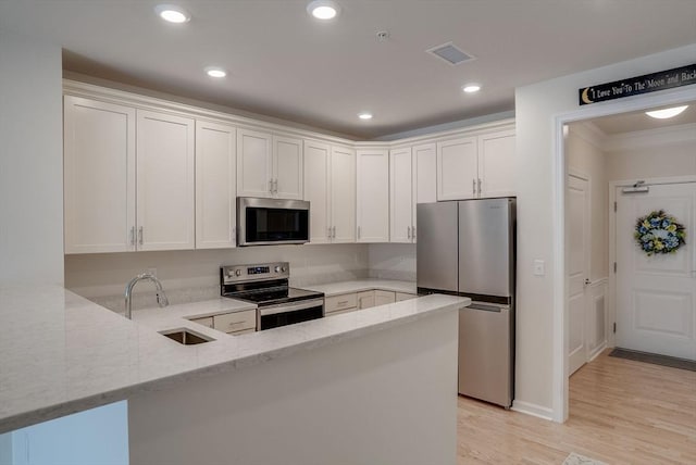 6 Overlook Dr Unit 207, Andover, MA 01810 - kitchen featuring stainless steel appliances, a sink, light stone counters, visible vents, and a peninsula
