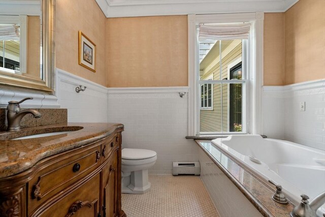 bathroom with vanity, a bath, a baseboard radiator, toilet, and a healthy amount of sunlight