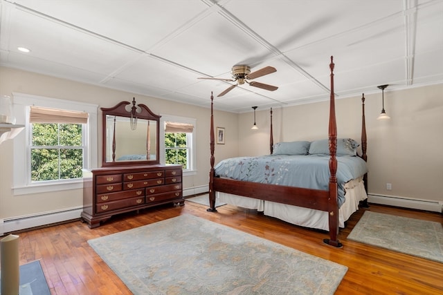 bedroom featuring multiple windows, ceiling fan, hardwood / wood-style flooring, and a baseboard radiator