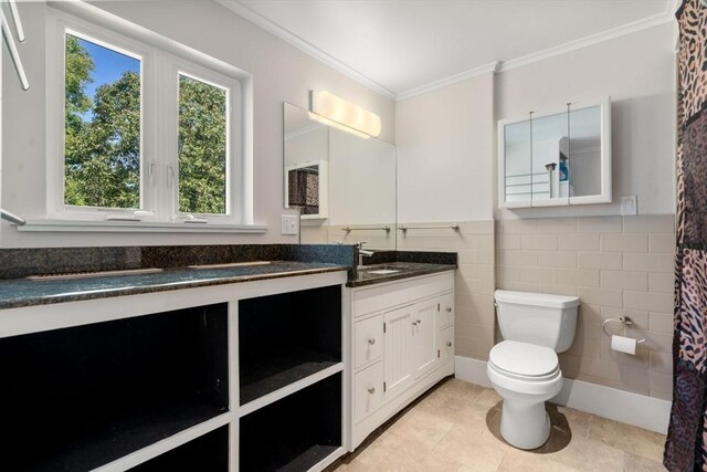 bathroom with tile patterned floors, toilet, ornamental molding, and vanity