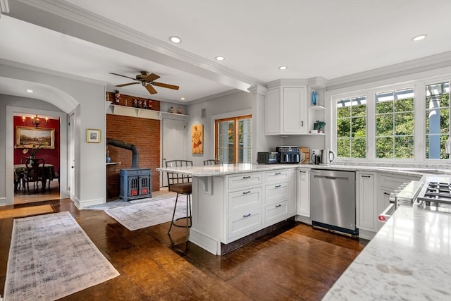 kitchen with a wood stove, dishwasher, a breakfast bar, kitchen peninsula, and ceiling fan