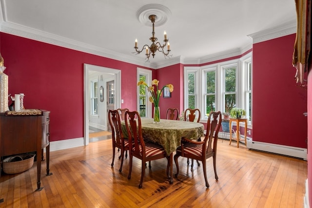 dining area featuring a baseboard radiator, ornamental molding, and light hardwood / wood-style floors