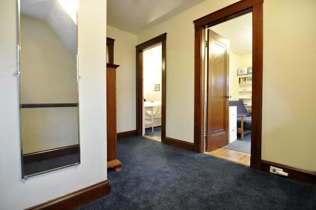 hall featuring dark colored carpet