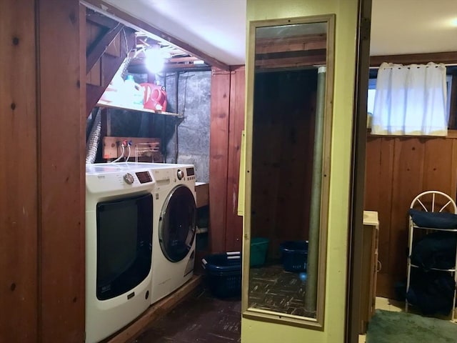 laundry room featuring washing machine and dryer and wooden walls