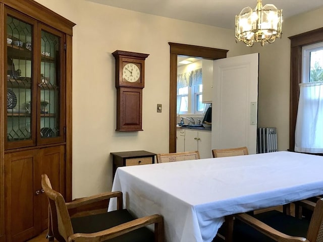 dining room featuring radiator heating unit, an inviting chandelier, and a wealth of natural light