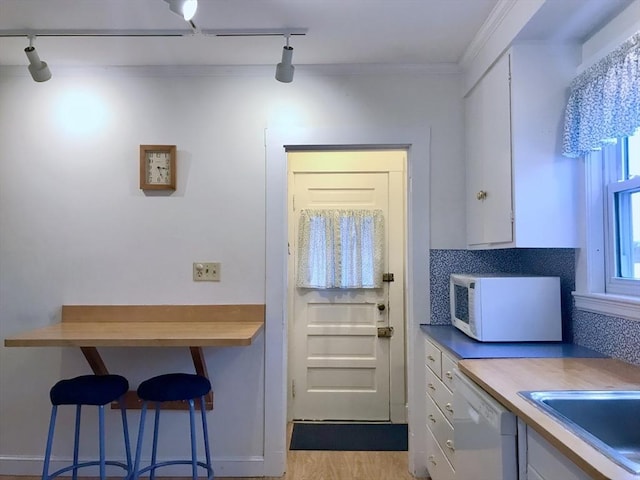 doorway with sink, ornamental molding, rail lighting, and light hardwood / wood-style flooring