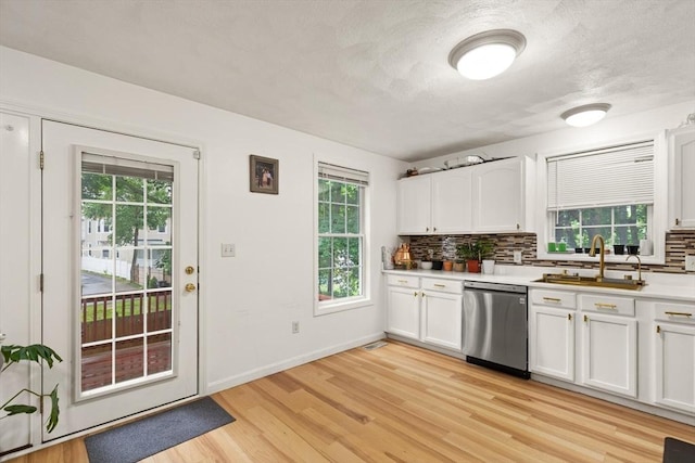 15 N St Unit 2, Haverhill, MA 01830 - kitchen with stainless steel dishwasher, light wood-style floors, tasteful backsplash, and white cabinetry