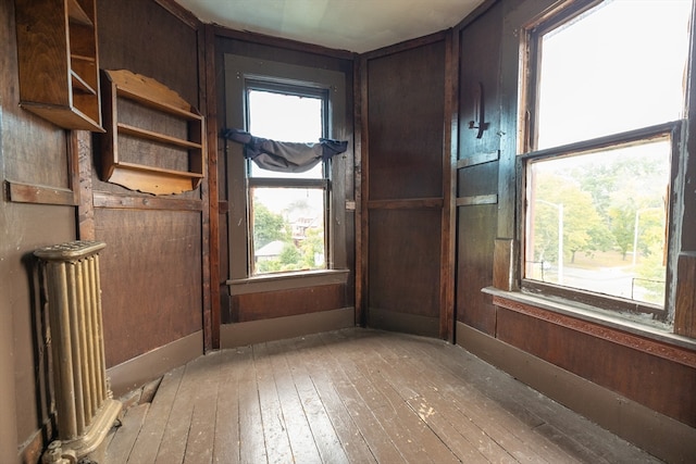 interior space featuring wooden walls, light wood-type flooring, and radiator