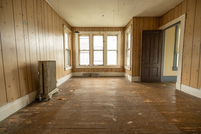 miscellaneous room featuring radiator, dark wood-type flooring, and wood walls