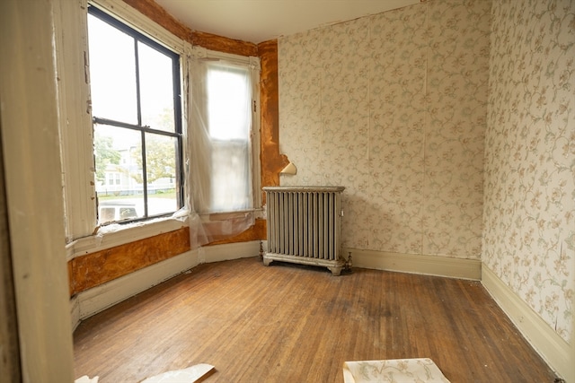 spare room with radiator heating unit and hardwood / wood-style floors