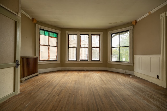 unfurnished sunroom featuring plenty of natural light and radiator