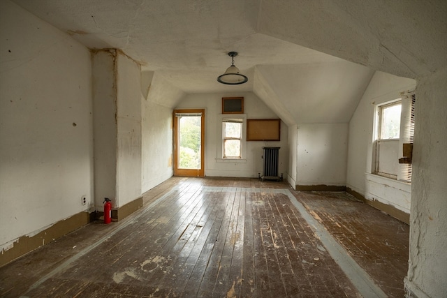 bonus room featuring lofted ceiling, radiator heating unit, and dark hardwood / wood-style flooring