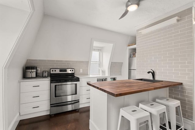 15 Beale St Unit 6, Boston, MA 02124 - kitchen featuring butcher block counters, appliances with stainless steel finishes, a sink, dark wood-type flooring, and a kitchen bar