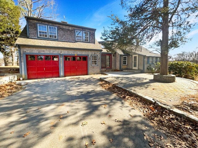 view of front facade featuring aphalt driveway and a shingled roof