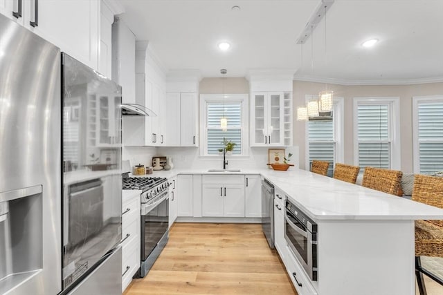 kitchen featuring stainless steel appliances, a breakfast bar, sink, and white cabinets