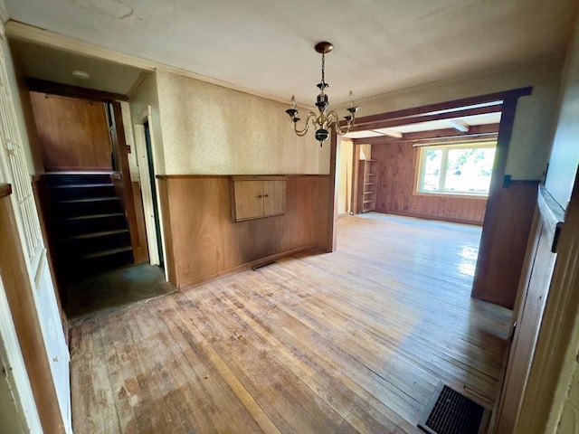 53 Morningside Path, Weymouth, MA 02189 - unfurnished dining area featuring a chandelier, light wood-style flooring, wood walls, wainscoting, and stairway