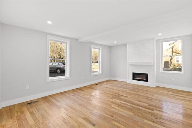 unfurnished living room with a fireplace and light hardwood / wood-style flooring