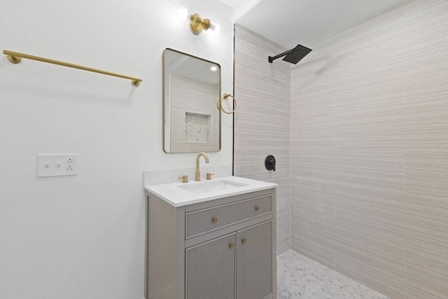 bathroom with a tile shower and vanity