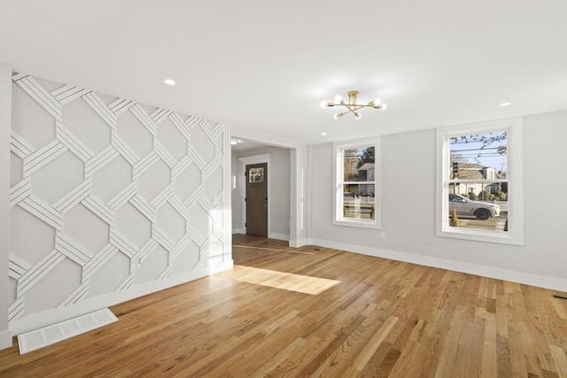 unfurnished room featuring hardwood / wood-style floors and a notable chandelier