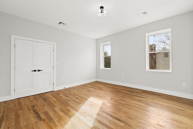 empty room with light hardwood / wood-style flooring and a healthy amount of sunlight