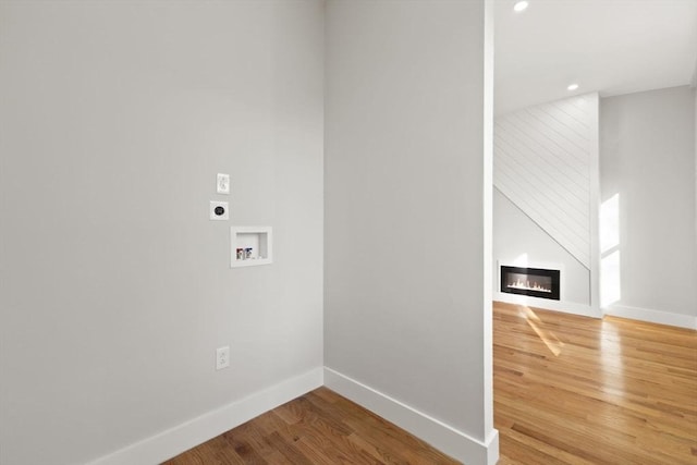 clothes washing area with washer hookup, a fireplace, hookup for an electric dryer, and hardwood / wood-style floors