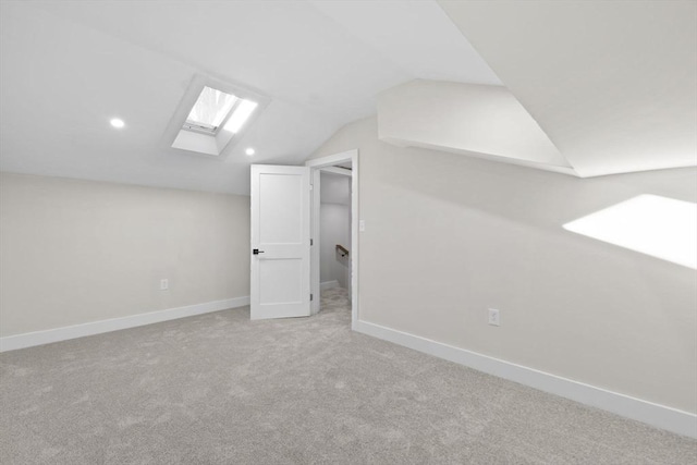 additional living space with light carpet and vaulted ceiling with skylight