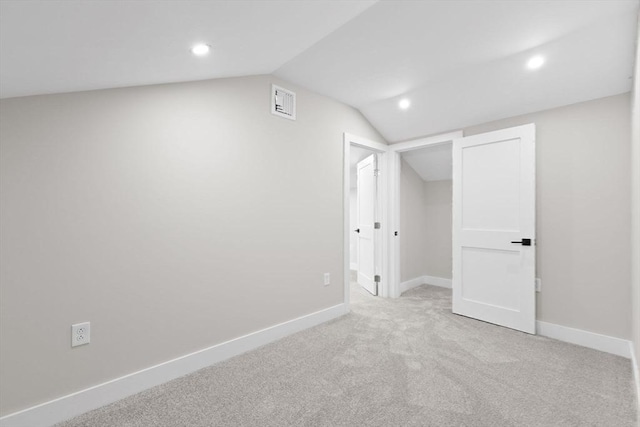 additional living space featuring lofted ceiling and light carpet