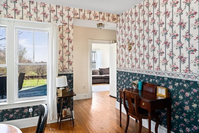 dining space with hardwood / wood-style flooring, a wealth of natural light, baseboards, and wallpapered walls