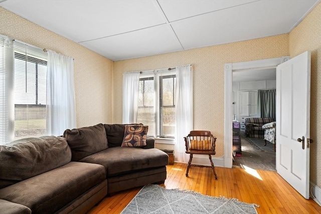 living room featuring a healthy amount of sunlight, light wood-type flooring, and wallpapered walls