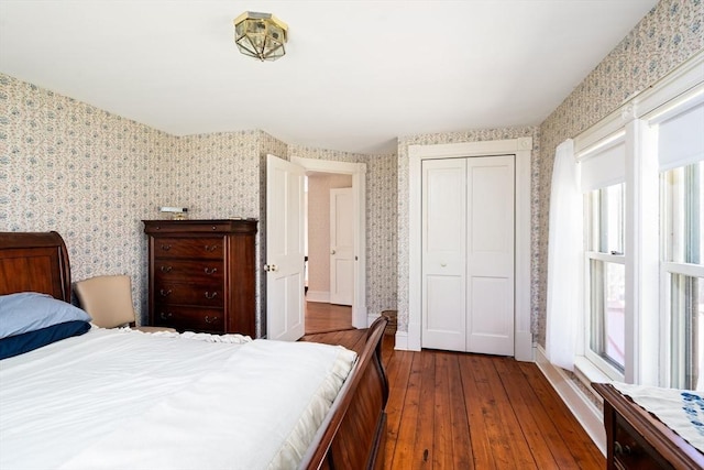 bedroom featuring wallpapered walls, multiple windows, and wood-type flooring