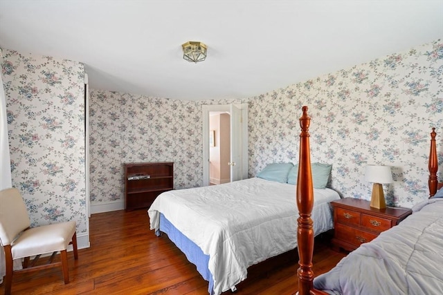 bedroom featuring wallpapered walls, wood finished floors, and baseboards