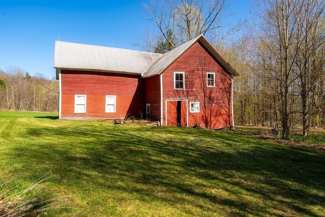 rear view of property featuring metal roof and a lawn