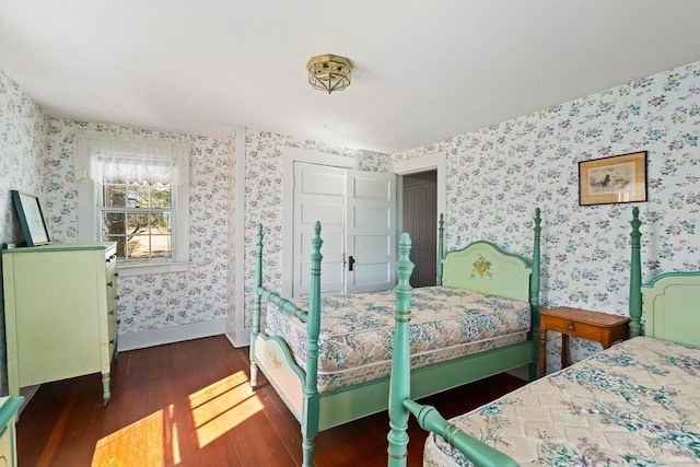 bedroom with baseboards, dark wood-style flooring, and wallpapered walls