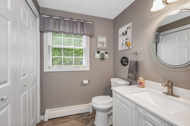 37 Sylvan Rd, Gardner, MA 01440 - bathroom with a baseboard heating unit, vanity, toilet, wood finished floors, and baseboards
