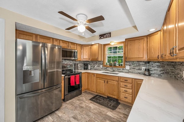 37 Sylvan Rd, Gardner, MA 01440 - kitchen with stainless steel appliances, a sink, a ceiling fan, a raised ceiling, and decorative backsplash