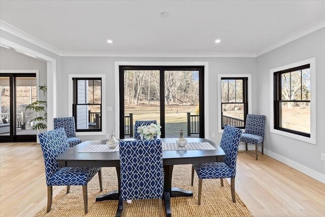 dining room with recessed lighting, baseboards, crown molding, and light wood-style floors