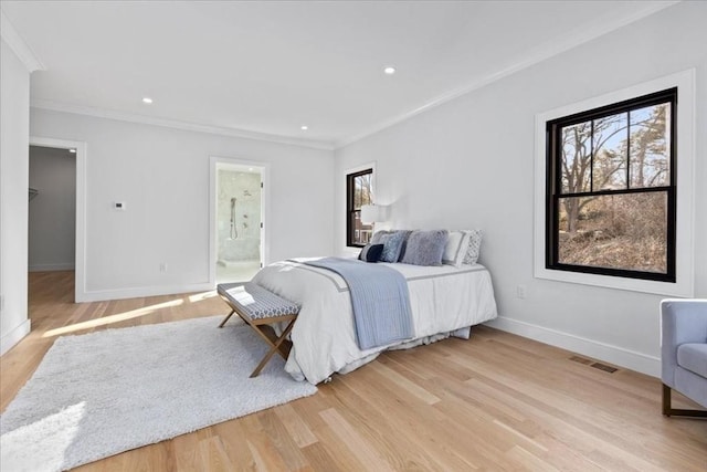 bedroom featuring visible vents, multiple windows, light wood-style floors, and crown molding