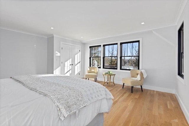 bedroom with light wood-style flooring, baseboards, and ornamental molding