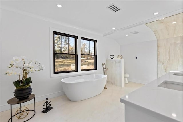 full bathroom with visible vents, toilet, recessed lighting, a freestanding tub, and a sink